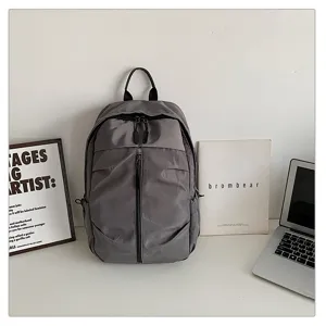 Mochila gris casual para hombre de gran capacidad en un entorno de oficina moderno.
