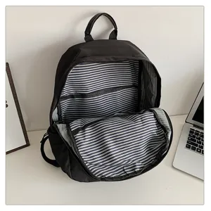 Vista detallada del interior de una mochila negra con forro interior de rayas