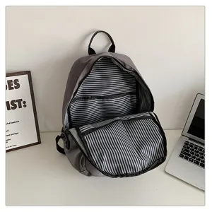 Vista detallada que muestra el interior espacioso y el forro a rayas de esta mochila gris