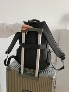 Mochila de viaje negra de gran capacidad con cinta para equipaje en asa de maleta