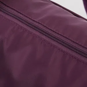 Close-up of durable zipper and purple nylon fabric on large capacity travel bag.