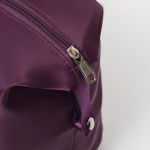 Close-up of durable metal zipper and purple nylon fabric on large travel bag.