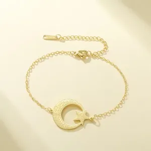 Vista detallada de pulsera de acero dorado con colgantes de luna y estrella