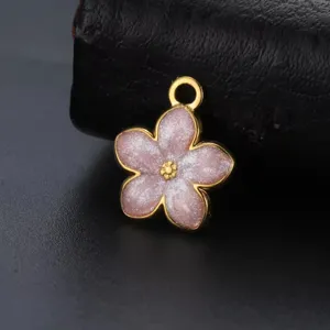Macro detail view of pink glittery enamel daisy flower pendant with gold plated metal border