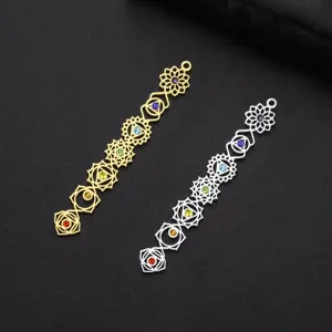 Detailed macro view of gold and silver stainless steel seven chakra pendants with gemstones.