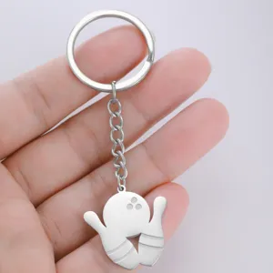 Close-up of a premium stainless steel bowling themed keychain held in hand with grey background