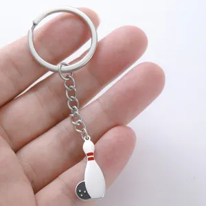 Stainless steel bowling pin keychain held by hand showing fine details and scale