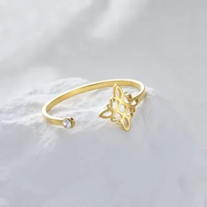 Detalle macro de un anillo de nudo de bruja en acero inoxidable dorado con una piedra de circón.