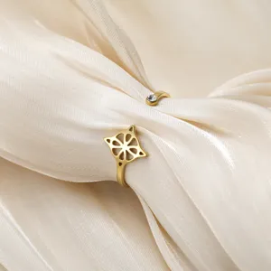 Vista macro de un anillo abierto de acero dorado con nudo de bruja y circón