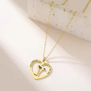 Close-up van gouden hartvormige ketting met zwemmermeisje-silhouet en gegraveerde tekst