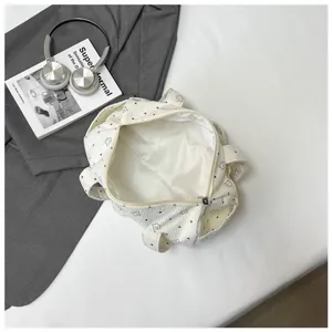 Vue intérieure détaillée d'un sac à main cylindre en velours côtelé blanc à motifs d'étoiles