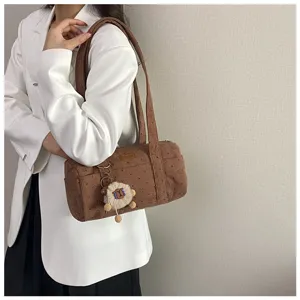 Sac polochon en velours côtelé marron avec motifs étoiles et pendentif mouton peluche.
