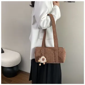 Vue détaillée d'un sac bandoulière en velours marron avec étoiles et breloque mouton