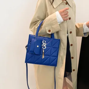 Stylish blue geometric quilted square crossbody handbag featuring a tassel and mini pouch charm