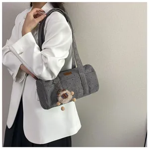 Sac à bandoulière cylindrique en velours côtelé gris avec motifs d'étoiles et charm peluche.