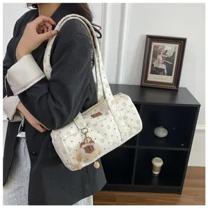 Détail du sac polochon en velours côtelé blanc avec étoiles et breloque ours