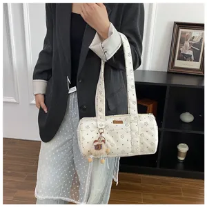 Détail du sac cylindre en velours côtelé blanc cassé avec motif étoile et porte-clé ours