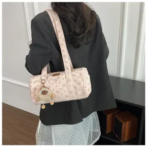 Gros plan du sac cylindre en velours rose avec motifs étoiles et charm mouton