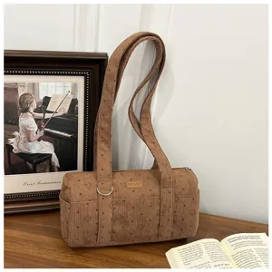 Détail du sac bandoulière cylindrique en velours côtelé marron avec motif d'étoiles