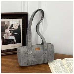 Vue détaillée du sac cylindrique en velours côtelé gris à motif d'étoiles et patch SPORT