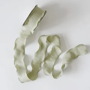 Detailansicht von hellgrünem Chiffonband mit eleganten Wellenkanten für DIY-Bastelarbeiten