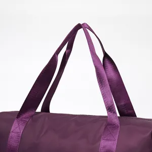 Close-up detail of reinforced purple nylon handles on a durable large travel duffel bag