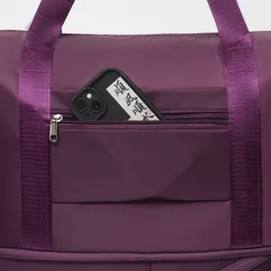 Close-up of large purple travel bag front pocket holding a smartphone