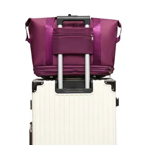 Large capacity purple travel duffel bag with rear trolley sleeve on white suitcase handle