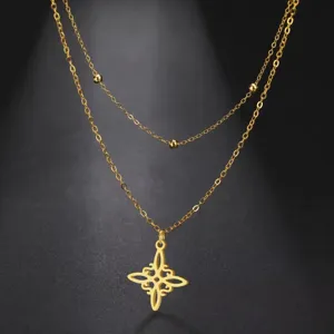 Detailed view of gold-tone double-layered stainless steel necklace with witch's knot pendant