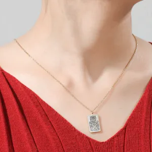 Gros plan d'un collier en acier inoxydable avec un pendentif carte de Tarot "The Chariot".