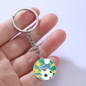 Macrodetail van geëmailleerde voetbal sleutelhanger met voetbal en voetbalschoen