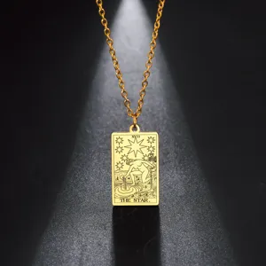 Gros plan du pendentif carte de tarot The Star en acier inoxydable doré avec gravure détaillée.