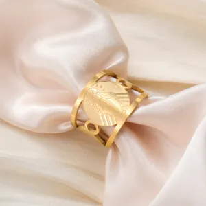 Gedetailleerde macro-opname van een vintage vergulde roestvrijstalen ring met religieuze gravure