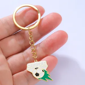 Detailopname van een gouden sleutelhanger met voetbalthema en wit en groen emaille