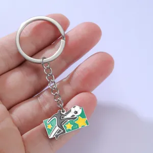 Gedetailleerde close-up van een emaille sleutelhanger met voetbalthema, speler en sterren.