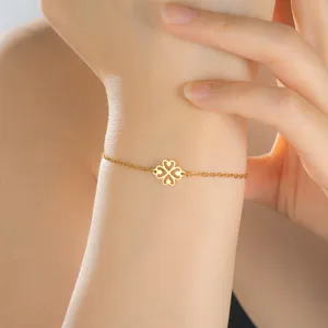 Detailed close-up of a gold stainless steel bracelet featuring a heart clover pendant on a wrist