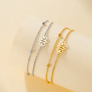 Detailed macro view of gold and silver stainless steel bracelets with African Adinkra symbols.