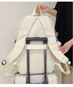 Détail d'un sac à dos blanc montrant la sangle de bagage pour un voyage facile