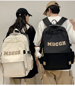 Vue arrière de modèles portant des sacs à dos à rabat de grande capacité en noir et crème