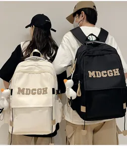Deux mannequins portant des sacs à dos noir et crème avec détails de porte-clés oie.
