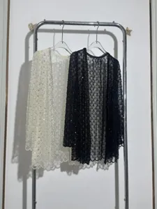 Detailed view of women's heavy beaded lace cardigans with sequins in black and white