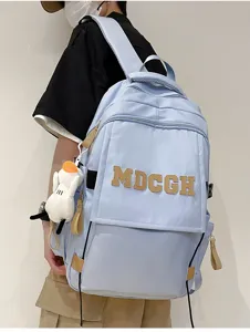 Vue détaillée d'un mannequin portant un sac à dos bleu clair de grande capacité et logo
