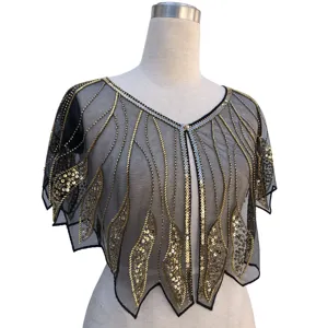 Close-up detail of a 1920s vintage black mesh shawl with gold and silver sequin patterns