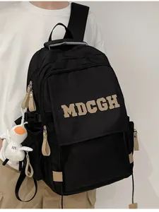 Étudiant portant un sac à dos noir à rabat avec lettres MDCGH et porte-clés astronaute