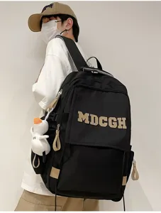 Détail d'un sac à dos noir à grande capacité avec broderie MDCGH et un porte-clés canard
