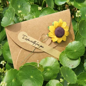 Biglietto d'auguri fatto a mano in carta kraft con girasole essiccato e adesivo speciale.