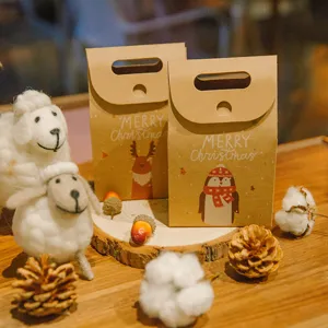 Twee kerstcadeautassen van kraftpapier met cartoonafbeeldingen van een rendier en pinguïn