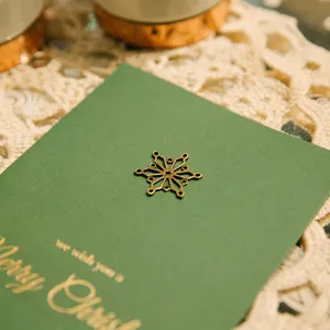 Charme flocon de neige en métal vintage sur carte de vœux de Noël verte.
