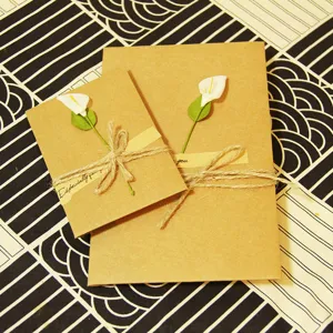 Biglietto d'auguri vintage in carta kraft con calla bianca essiccata e fiocco di spago