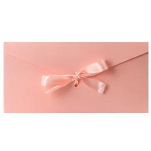 Elegante busta in carta perlata rosa con fiocco di nastro di seta per inviti regalo.